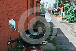 Yahama RX 100 model motorcycle parked at the back of a building.