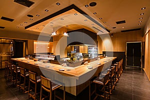 Yakitori Japanese Grilled Skewer Restaurant with counter bar around the grill kitchen area. Mostly decorated with oak wood texture photo