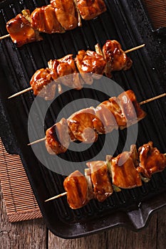 Yakitori skewers of chicken on a grill pan close-up. vertical to