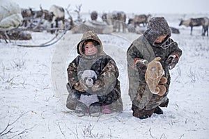 The Yamal Peninsula  the extreme north. Happy boy and girl on reindeer herder pasture in a cold winter day  polar circle  children