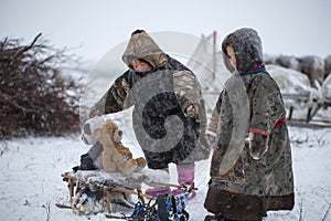 The Yamal Peninsula  the extreme north. Happy boy and girl on reindeer herder pasture in a cold winter day  polar circle  children