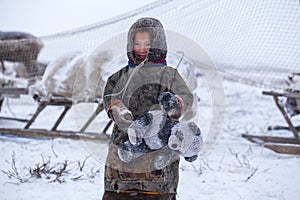 The Yamal Peninsula. Happy boy on reindeer herder pasture plays outside on a cold winter day, far north