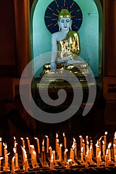Candles and Buddha in the Shwedagon Pagoda in Yangon