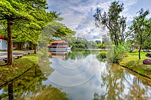 Yao-Yueh Fang Stone boat structure in a pound in Chinese Singapore garden with blue cloudish and reflection