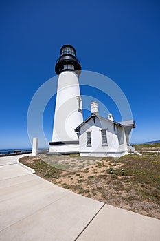 Yaquina Head Lighthouse against blue sky, along Pacific coast in Oregon, USA photo