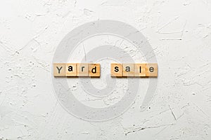 Yard sale word written on wood block. Yard sale text on cement table for your desing, Top view concept