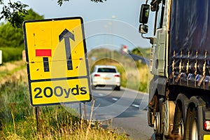 200 yards roadworks warning sign on UK motorway at evening with traffic passing