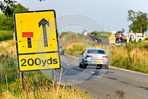 200 yards roadworks warning sign on UK motorway at evening with traffic passing