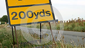 200 yards roadworks warning sign on UK motorway at evening with traffic passing