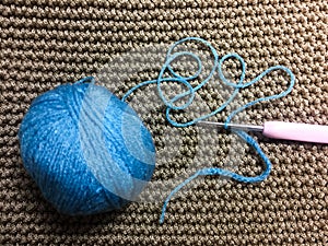 Yarn ball and Hook on blown crochet background