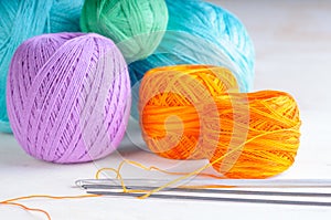 Yarn balls and crochets on the wooden background