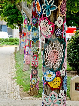 Yarn bombing in trees. European park.