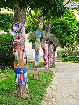 Yarn bombing in trees. European park.