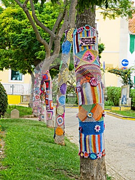 Yarn bombing in trees. European park.