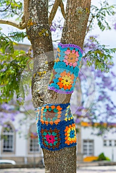 Yarn bombing in trees. European park.