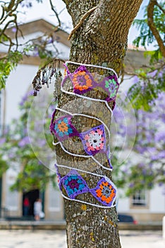 Yarn bombing in trees. European park.