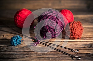 Yarn and knitting needles on a rustic wooden background