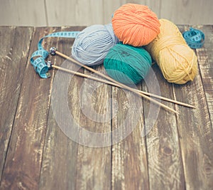 Yarn with knitting needles on wooden background