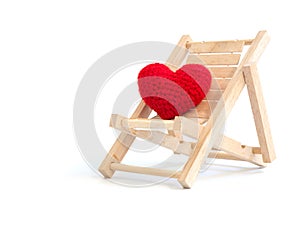 Yarn red heart on the wooden beach chair on white background isolated. copy space for text. Valentines day, love concept and lov