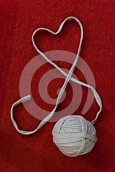 Yarn of wool in heart shape symbol with crochet hook