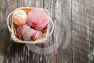 Yarn in worven basket; old wood planks background