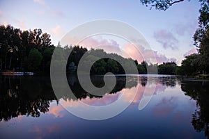 Yaroslavl. Warm evening in Neftyanik Park. Park refinery. Reflection of colorful sunset in the lake. Peace and quiet surrounded by