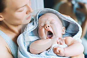 Yawning cutest baby after bath with towel on head.