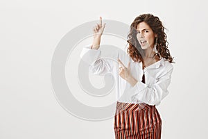 Yeah look here. Portrait of confident good-looking european woman with curly hair, gazing self-assured at camera while