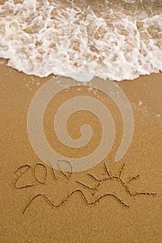 Year 2010 written on sand