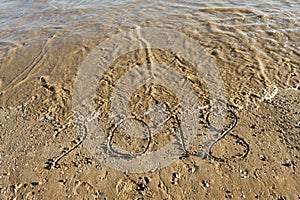 Year 2018 written in the sand of the beach