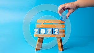 Year of 2022 printed on wooden blocks on cyan background