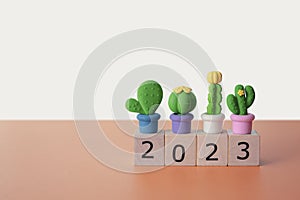 The year 2023 with Cactus model objects for background.