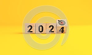 The year 2024 target dart on yellow background. 2024 business planning and strategy concept. investment trends next new year