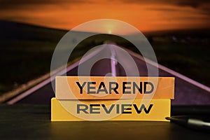 Year End Review on the sticky notes with bokeh background