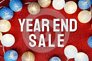 Year End Sale text and LED cotton Balls Decoration on red Glitter background