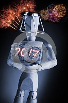 Year 2016, manikin mannequin human artist drawing model holding a wine cork on black background with fireworks.