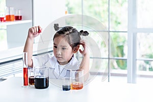 A 4 year old Asian girl wearing a white scientist uniform Learning And conducted a scientific photo