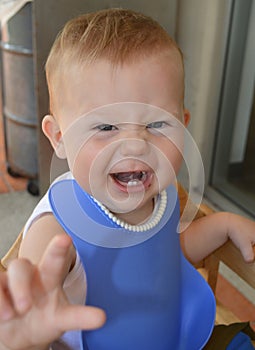 Year old baby with funny scrunched expression showing teeth