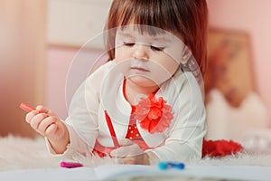 1 year old baby girl drawing with pencils at home