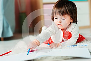 1 year old baby girl drawing with pencils at home