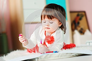 1 year old baby girl drawing with pencils at home