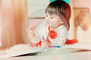 1 year old baby girl drawing with pencils at home