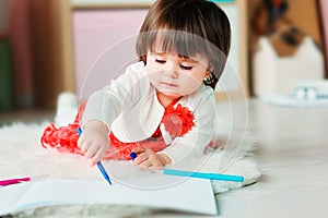 1 year old baby girl drawing with pencils at home