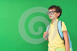 7-year-old boy with backpack on his back, looking into distance