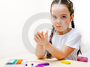 A 5-year-old girl independently sculpts figures from plasticine