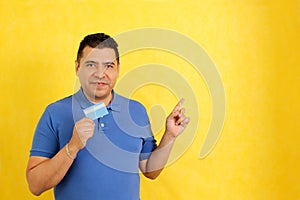 40-year-old Latino man shows his credit or debit card happy to use it in discounts and promotions in store and online purchases photo