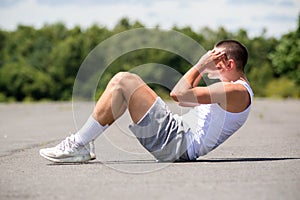 A 19 Year Old Teenage Boy Doing Situps In A Public Park