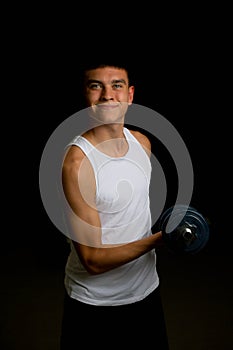 Nineteen year old teen boy exercising with a dumbbell