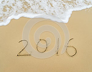 Year 2016 written in sand on beach