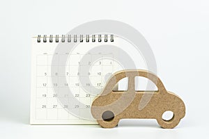 Yearly car maintenance schedule, car loan payment, mortgage and leasing concept, miniature wooden car on clean calendar with date